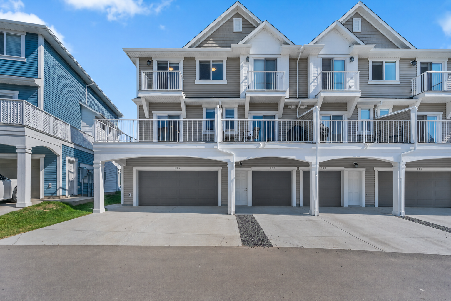 Townhouse exterior in Copperfield with upper balcony and garage bays